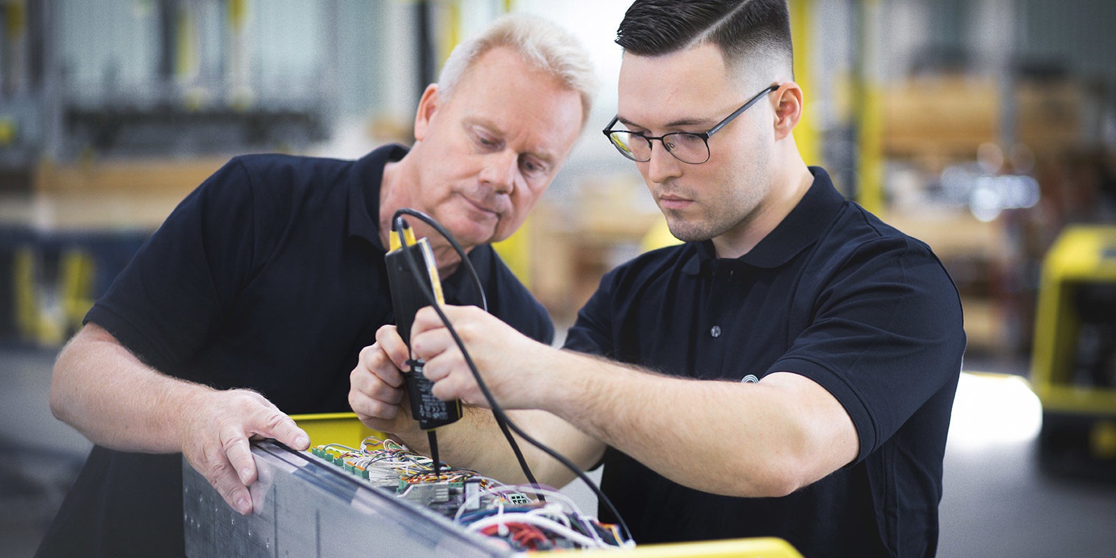 Beispielbild Ausbildung bei psb mit einem Meister der einem Auszubildenden über die Schulter schaut