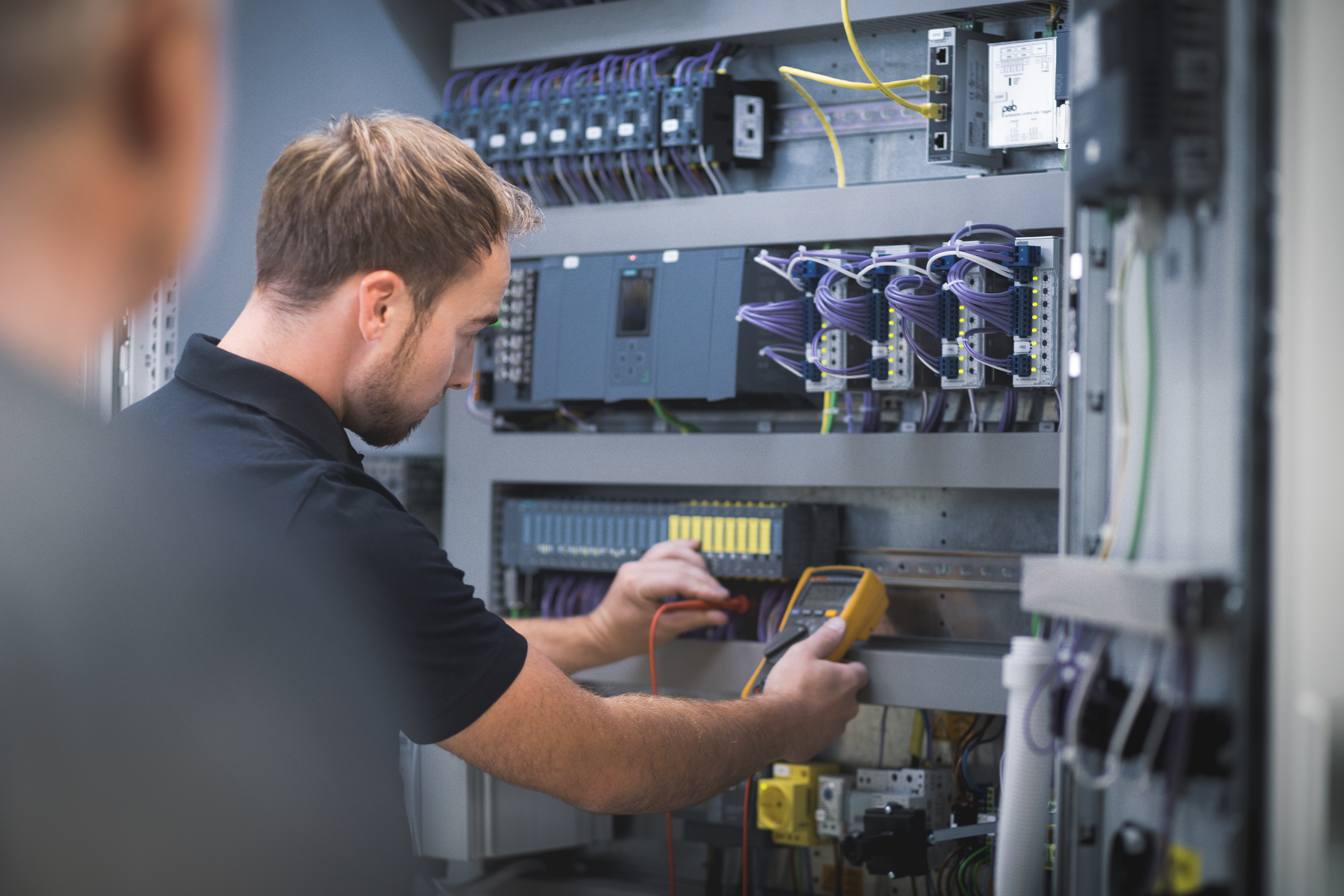 Beispielbild Elektroniker für Betriebstechnik (m/w/d) bei der Arbeit an internen Schaltmodulen