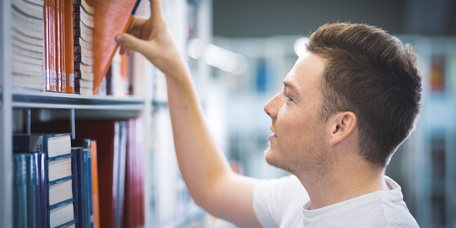 Beispielbild zum Wirtschaftsingenieurwesen. Zukünfiter Ingenieur bei der Auswahl an Büchern.