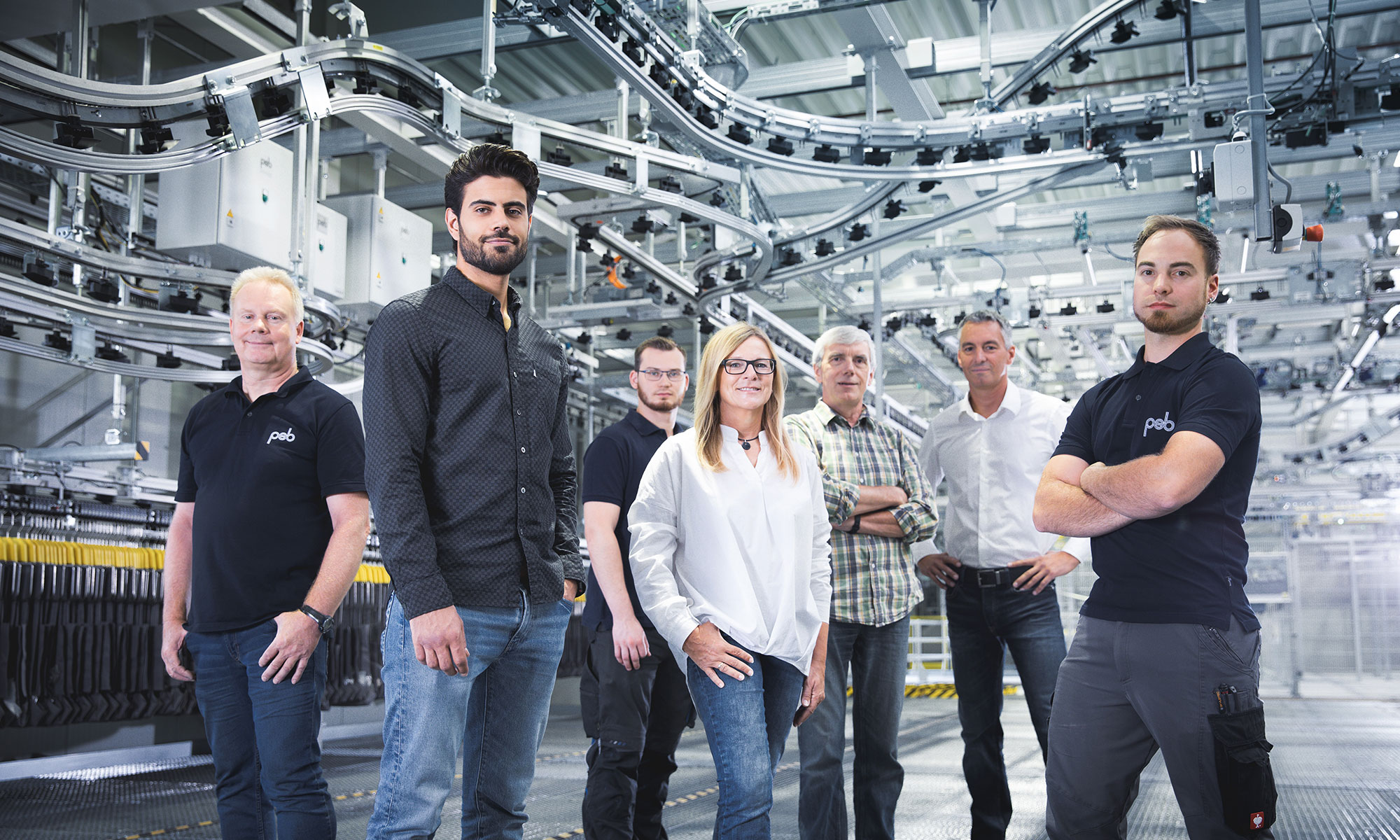 Team von psb Mitarbeitenden vor Hängebahn und Sortieranlage
